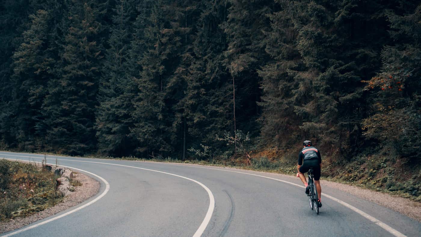 Ciclista numa estrada de montanha, imagem contextual para uma etapa do Tour feminino.