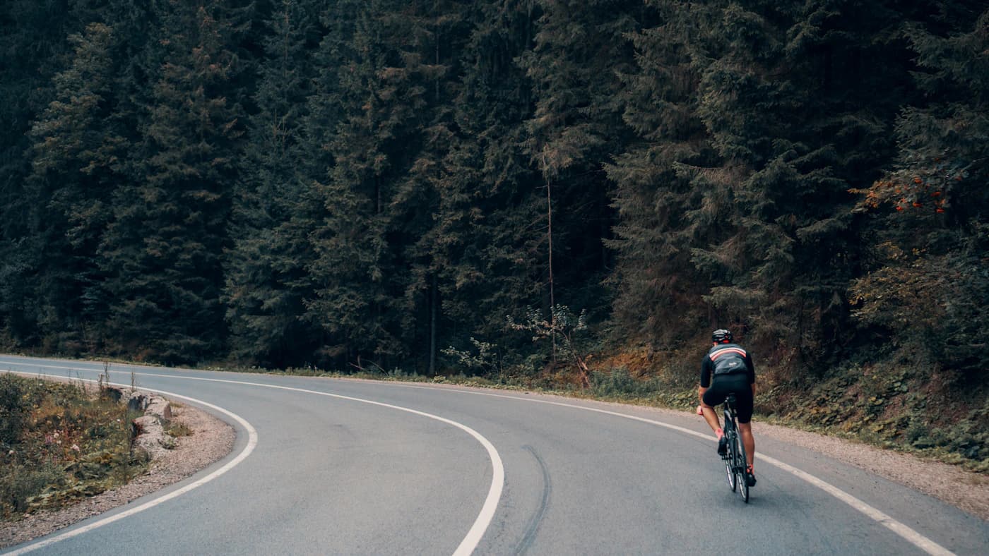 Ciclista numa estrada de montanha, imagem contextual para uma etapa do Tour feminino.