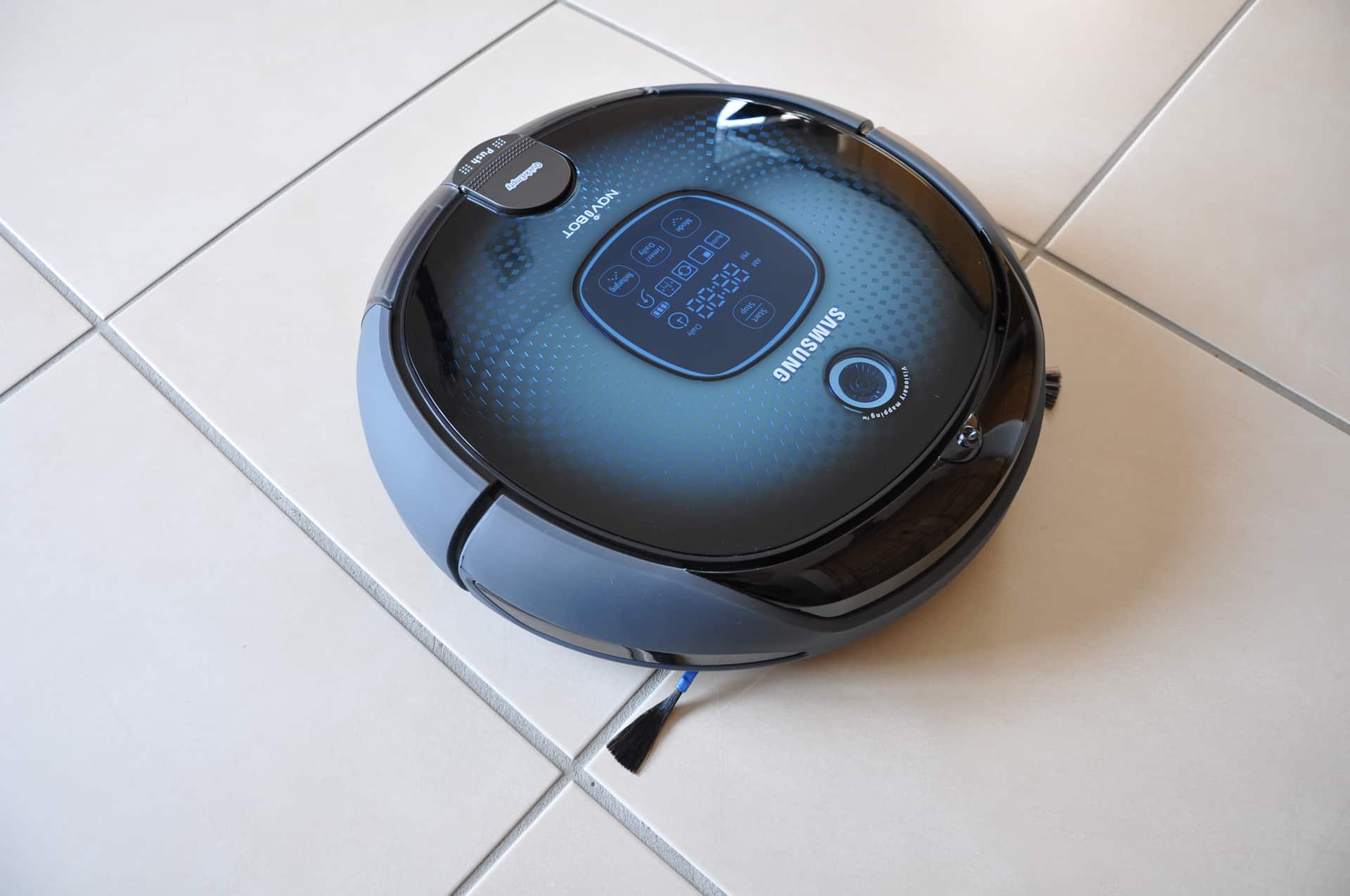 Robô aspirador Samsung fotografado sobre um piso claro